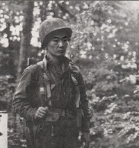 Sgt. James Kawashima (Honolulu) standing guard near Co. B command post at Bruyeres, France.  [U.S. Army Signal Corps]