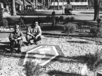 Two soldiers sit with the 442nd Regimental Combat Team “Go For Broke” insignia, made with painted rocks. Tombolo, Italy, 1946 [Courtesy of Bernard Akamine]