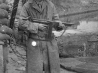 Frank Wada with submachine gun on guard duty at the Red Cross Warehouse. [Courtesy of Bernard Akamine]