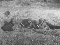 Three soldiers catch up on the news while in a trench in Italy, 1944. [Courtesy of Mary Hamasaki]