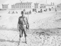 Tadayoshi Hamasaki on the beach with some men of the mortar platoon in the background. [Courtesy of Mary Hamasaki]