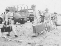 Soldiers disembark from transport vehicles with their belongings. [Courtesy of Mary Hamasaki]