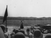 Taken August 9, 1942 at the shooting range here at Camp McCoy, Mrs.  Lapperweins exhibiting her marksmanship and her husband holding the target.  Bulls eye in every shot.  Husband and wife-best team shooters in Winchester rifles of all makes and models.  Accurate shooters both and we were treated to a  fine exhibition  of rifle shooting by both.  [Courtesy of Jan Nadamoto]