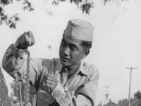 Curious huh?  Taken in camp just back of our row of tents. Sept. 1, 1942 Notice the shirt sleeves too long, bought a new one, and still have to have it fixed.   Camp McCoy, Wis.  [Courtesy of Jan Nadamoto]