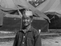 Taken September 1, 1942 in company street.  Camp McCoy, Wis. Note: Oversized blouse the same one I had back still not fixed sleeves about  6" long and oversized pants.  Could make 4 pleats and still would be too big and about 8" long.  [Courtesy of Jan Nadamoto]