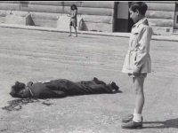 Italian boy looks on at dead “Collaborator” killed in Milan Park, 1945. [Courtesy of Fumie Hamamura]