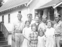 Sueo Noda, Dad, Ma, Walter, Tokuji Ono, Pat, Sharleen, Sandy, Diana standing in front of a house in Wisconsin [Courtesy of Leslie Taniyama] Inscription:Sueo, Dad, Ma, Walter, Tokiji. Pat. Sharleen, Sandy, Diana. Reverse: Zelany(Zilany) family, West Allis, Wisconsin. Family who befriended us & w/whom we spent a number of weekends. 1942