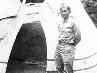 Tokuji Ono standing with hands behind his back in front of an Indian teepee at Stand Rock [Courtesy of Leslie Taniyama] Inscription: Reverse: 7-5-42 'Yours Truly', Bullie. At 'Stand Rock', Winnebago Indian ceremonial ground on the Wisconsin River