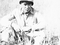 Goro Sumida sitting in the grass at Camp McCoy, Wisconsin [Courtesy of Goro Sumida]