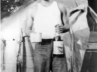 Richard Yoneshige at Camp Shelby with a bottle of wine [Courtesy of Ukichi Wozumi]